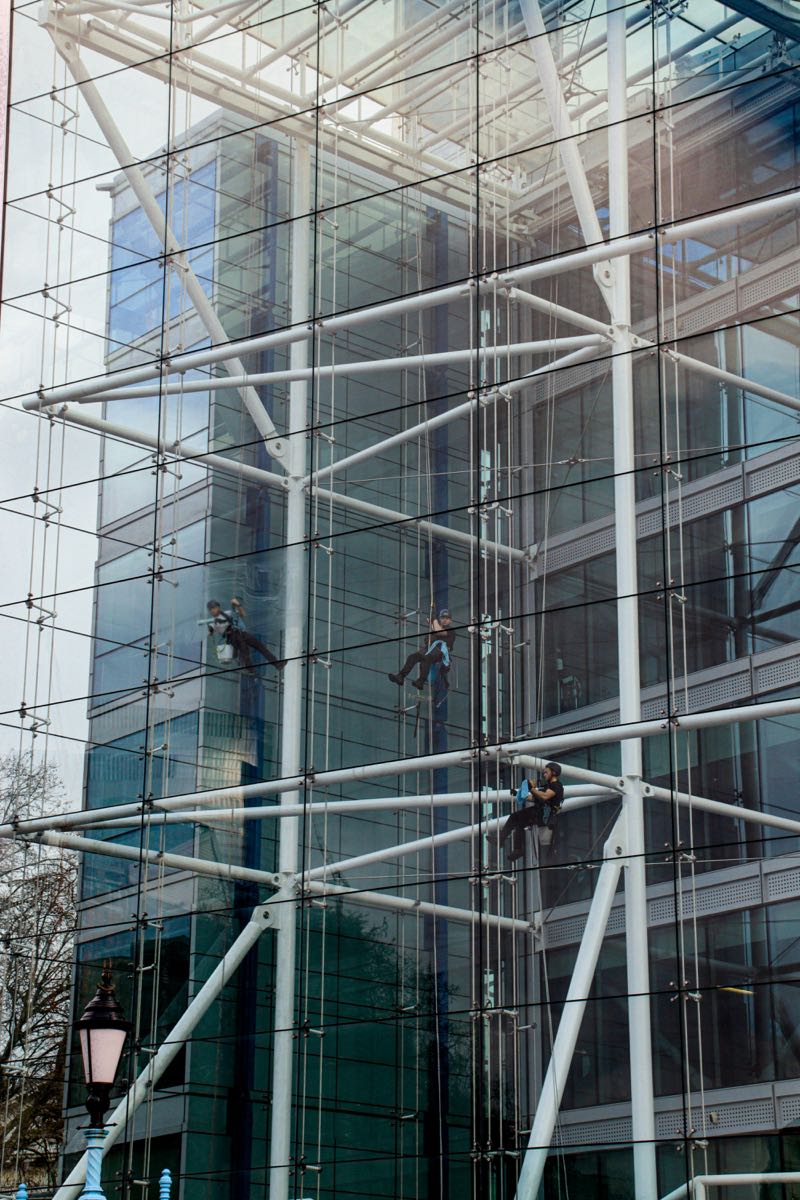 Cordistes en intervention sur façade vitrée d'immeuble de bureaux